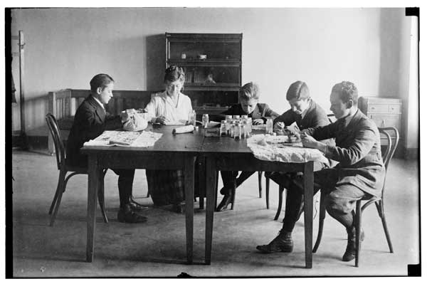 Seed Testing.  1921 Class of 4 boys with Miss Etta Simpson seated at table.