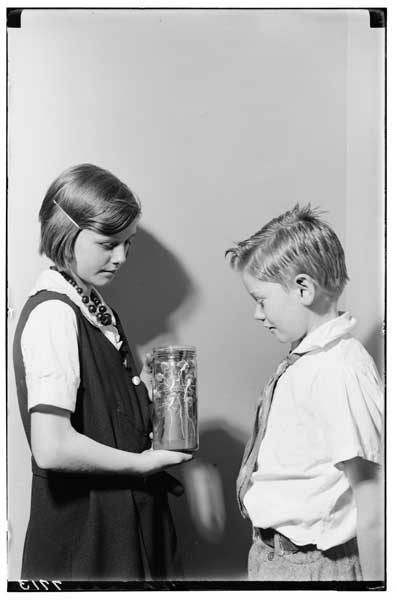 Bean, root system of.  Elizabeth and Thomas Degen with experiment in glass jar-1932.